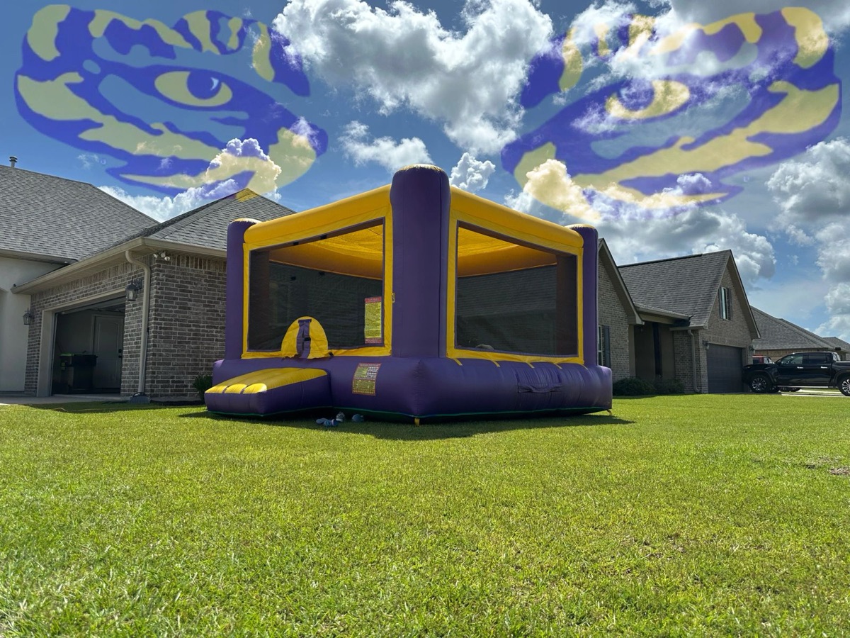 Purple and gold 15 by 15 foot bounce house in a backyard