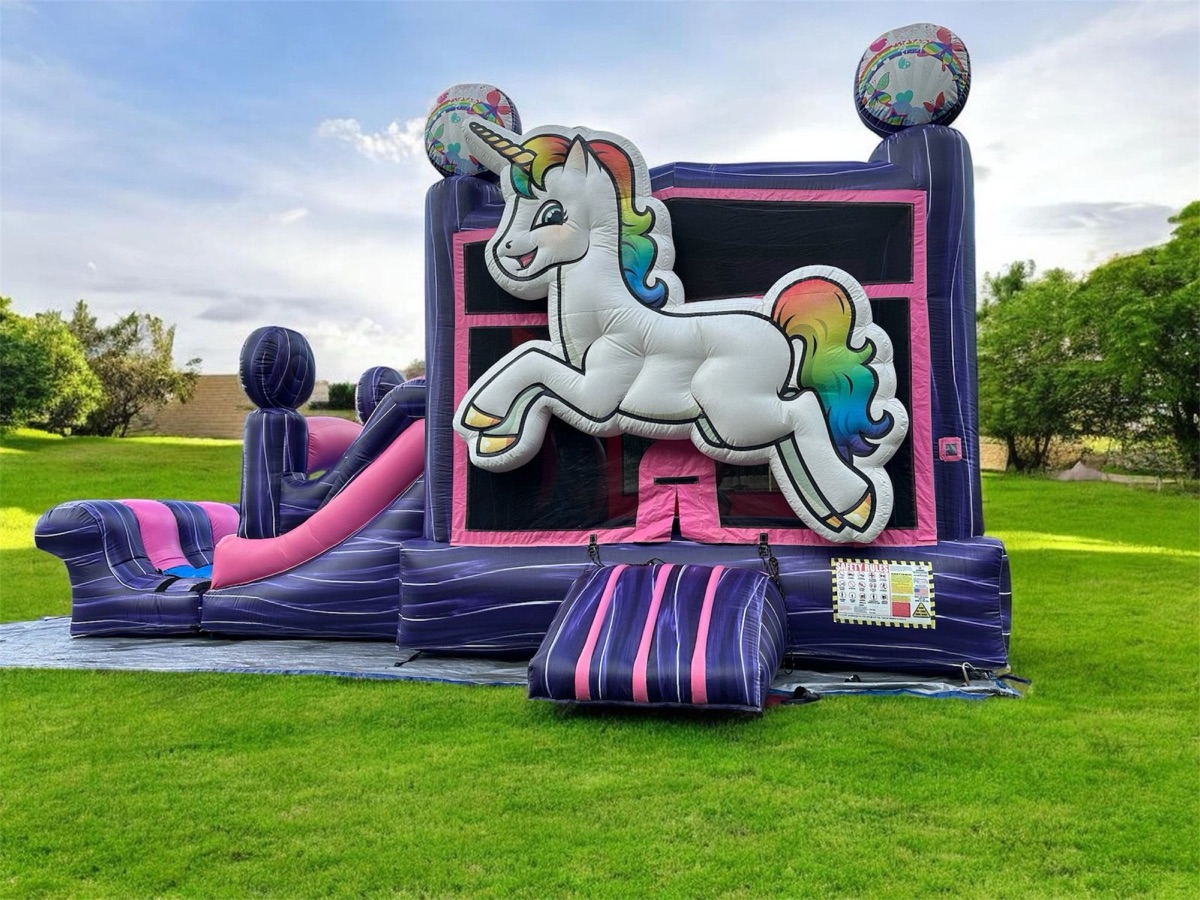 Unicorn themed inflatable bounce house with slide on grass